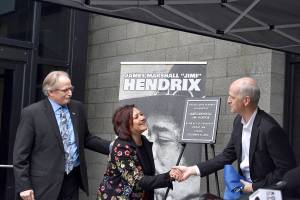 USPS district manager Darrell Stoke, Janie Hendrix and Congressman Adam Smith (D-WA) unveil the plaque honorarily naming the Renton Highlands Post Office as the James Marshall Jimi Hendrix Post Office on Friday, April 19. Photo by Haley Ausbun