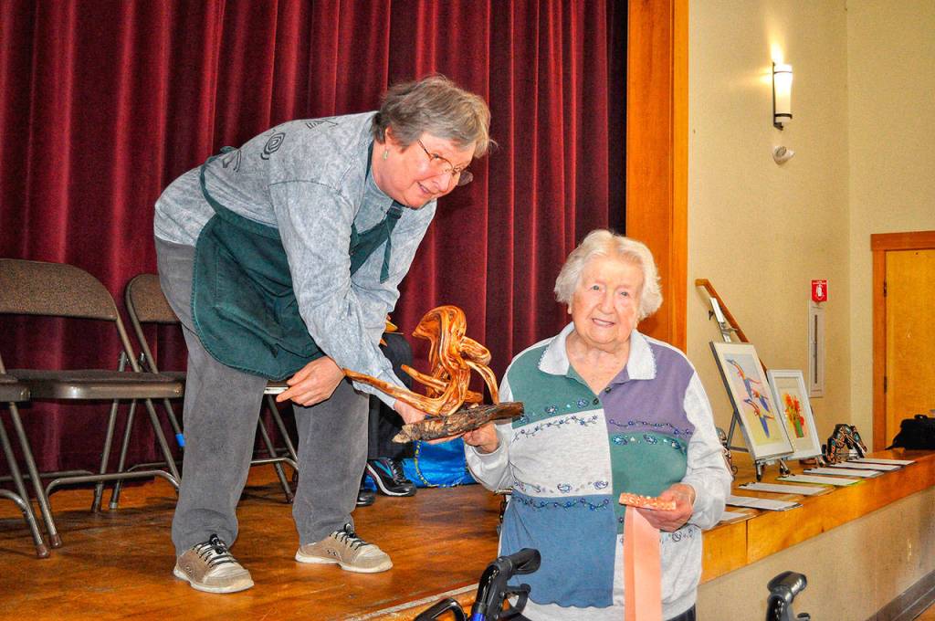 99-year-old Sandy Mathewson receives her peoples choice ribbon for her driftwood sculpture titled, Otto the Octopus from her daughter and teacher Alice Shuler. Courtesy photo of Northshore Senior Center