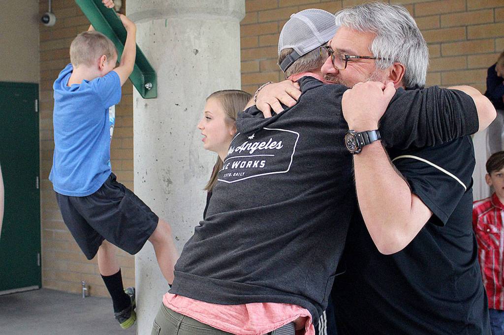 Ted Christensen hugs his nephew and former student, Kip Barnes, at his retirement party. Madison Miller / staff photo