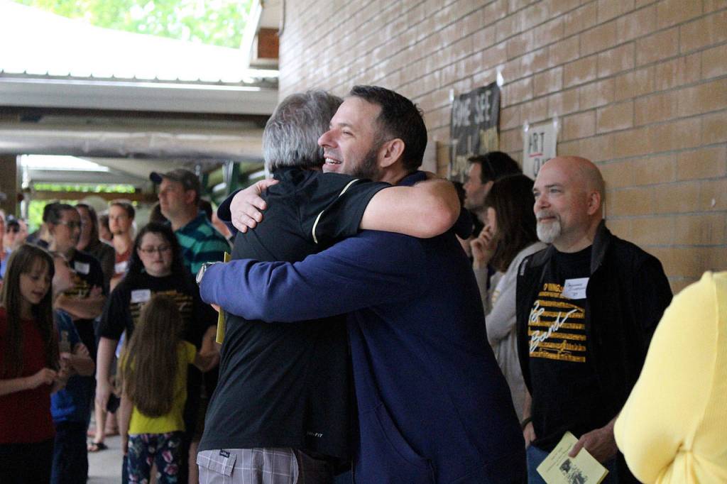 Ted Christensen hugs former student, Ron Gilchrist (class of 1989) at his surprise retirement party. Madison Miller/ staff photo