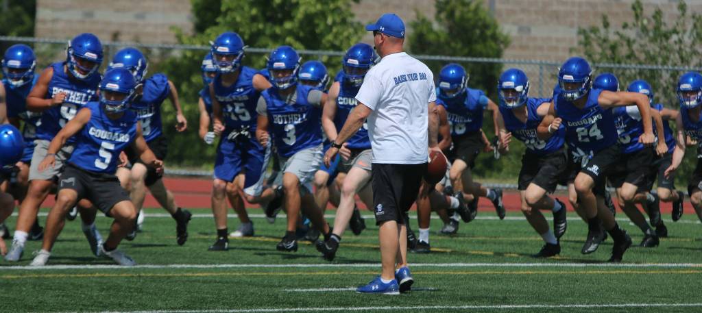 Bothell players get in some running while head coach Tom Bainter gives instructions on June 13. Andy Nystrom / staff photo