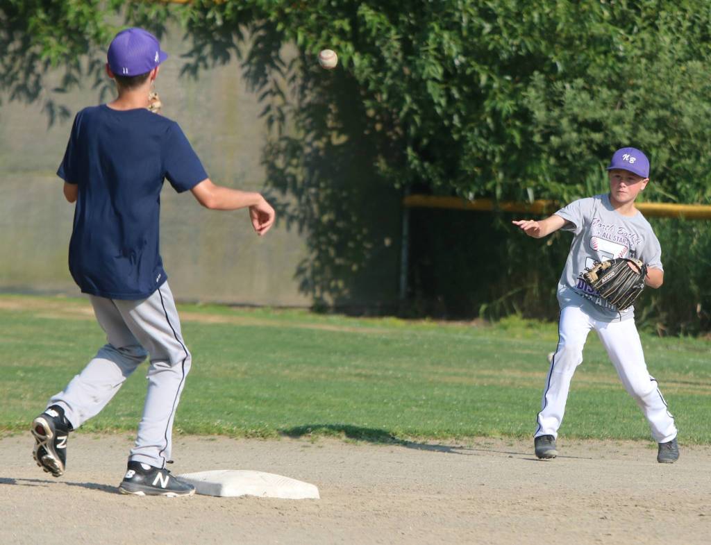 North Bothells Aksel Keim, right, throws the ball to Dominic Wilson during a double-play drill. Andy Nystrom/ staff photo