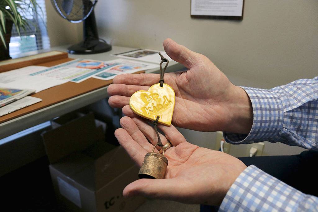 Stephanie Quiroz/staff photo                                 Paul Brown looks at his Be Kind bell he received following the Marysville Pilchuck High School shooting.