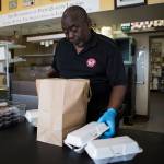 Carolina Smoke owner David Hayward packages up orders to go on March 22 in Bothell. Olivia Vanni/staff photo