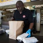 Carolina Smoke owner David Hayward packages up orders to go on March 22 in Bothell. Olivia Vanni/staff photo
