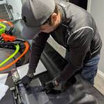 Ryan Schwalb punches holes in a transparent film to attach the face shield to a mask frame, creating personal protection equipment for frontline health care workers. Photo courtesy of Ryan Schwalb