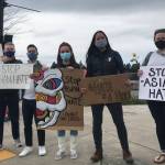 Rally participants hold signs in support of AAPI community (photo credit: Cameron Sheppard)