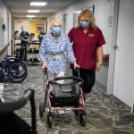 CNA Nina Prigodich, right, goes through restorative exercises with long term care patient Betty Long, 86, at View Ridge Care Center on Friday, Feb. 10, 2023 in Everett, Washington. (Olivia Vanni / The Herald)