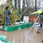 Ruby Randolph, 16, helps her dad Steve Randolph, a board member for Sustainable Renton, build up another wall of sandbags late Dec. 11 as water from the Cedar River seeps into the backyard of a Maplewood resident. Photo by Bailey Jo Josie/Sound Publishing