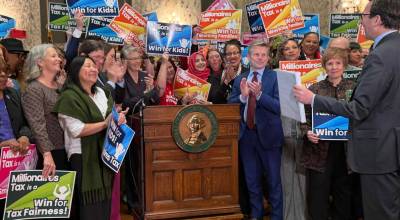 Supporters of Washingtons new income tax on millionaires celebrate as Gov. Bob Ferguson prepares to sign it on Monday, March 30, 2026, in Olympia. (Photo by Aspen Ford/Washington State Standard)